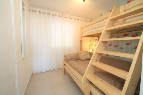 ミアミ・プラトーヤにあるNEW! Modern apartment right on the beach!の小さなベッドルーム(二段ベッド1組、はしご付)