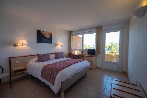 Un dormitorio con una cama grande y una ventana en Hotel Les Galets en Saint-Florent