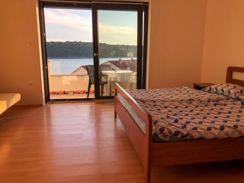 a bedroom with a bed and a large window at Apartments Palit Rab in Rab