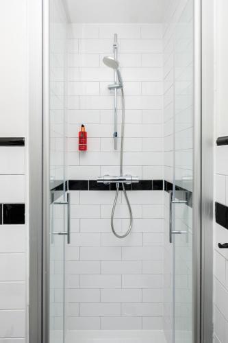 a shower with a red bottle on a shelf in a bathroom at Hotel Brasserie Smits in Wemeldinge
