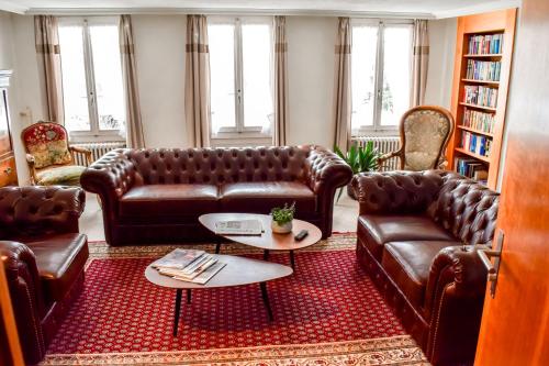 a living room with leather couches and a table at First Lodge in Grindelwald