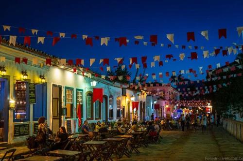 eine Straße in der Nacht mit Leuten, die an Tischen sitzen in der Unterkunft Casa Colibri - Praias e Cachoeiras in Paraty
