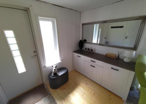 eine Küche mit einem Tisch, einem Spiegel und einem Fenster in der Unterkunft Prangli Valgekivi in Kelnase