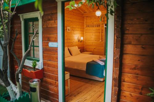a room with a bed in a wooden house at Pirlanta Butik Hotel in Çeşme