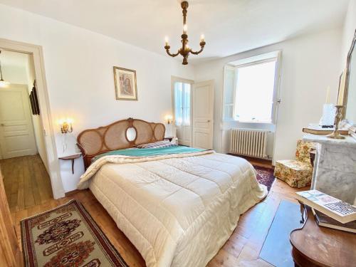 a bedroom with a large bed and a chandelier at CASA L'ARBI in Pino Lago Maggiore