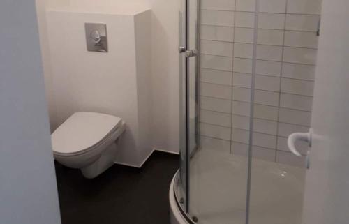 a bathroom with a toilet and a glass shower at M18 in Copenhagen
