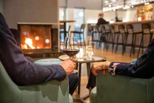two people sitting in chairs holding a glass of wine at TUI BLUE Sylt in Rantum