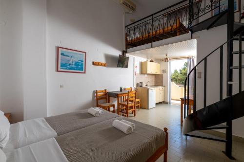 1 dormitorio con 1 cama, cocina y escalera en Pefkos View Apartments en Pefki Rhodes