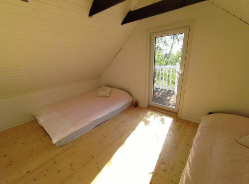 Kleines Zimmer mit einem Bett und einem Fenster in der Unterkunft Prangli Valgekivi in Kelnase