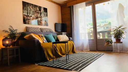 a living room with a couch and a window at Appartement vue Montblanc 5mn piste1 in Les Houches
