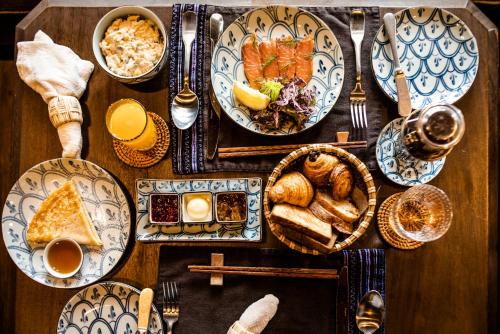Una mesa de madera con platos de comida encima. en Zannier Bai San Hô, en Song Cau