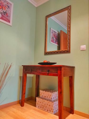 a wooden table with a mirror on a wall at A Casiña do Patio in Quiroga