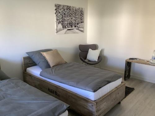 a bedroom with two twin beds and a chair at Pension N-Ring in Nürburg