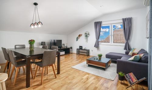 a living room with a table and a dining room at Family Petrov Apartments in Vodice