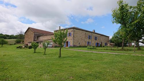 un gran edificio de ladrillo con árboles en un campo en Gîtes & Chambres d'hôtes Peyrecout en Laparrouquial