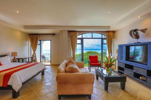 a living room filled with furniture and a tv at Shana by the Beach Manuel Antonio in Manuel Antonio