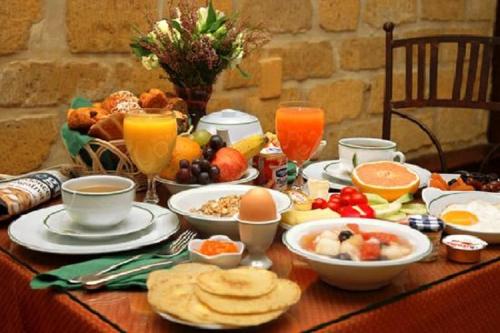 uma mesa com alimentos e bebidas para o pequeno almoço em Hotel Maison du Général em Quebeque