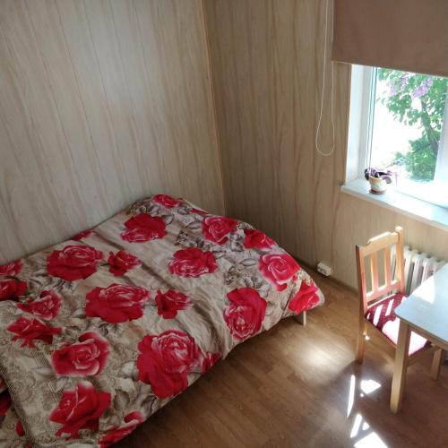 a bed with red roses on it in a room at Kanepi accommodation One room in Viljandi