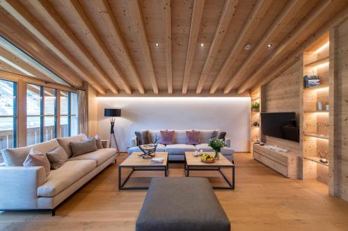 a living room with a couch and a tv at Brunnenhof Luxury Apartments in Lech am Arlberg