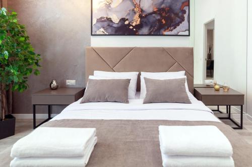 1 dormitorio con 1 cama grande y 2 mesas en Avangard Franko* Art Apartment, en Leópolis