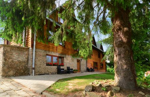 a house with a tree in front of it at Pensjonat Lesniczówka bieszczady solina polańczyk in Polańczyk