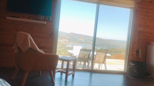 a room with a table and chairs and a large window at צימר סאפי in Nimrod
