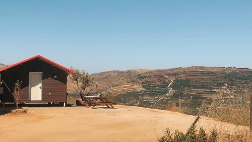 a cabin with a bench in front of a mountain at צימר סאפי in Nimrod