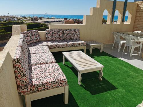 a patio with two couches and a table on a balcony at La Stanza Chalet in Dawwār ‘Abd al ‘Aţī Abū ‘Ajūz