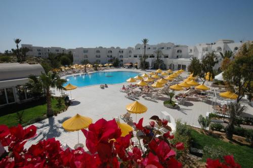 una vista aérea de una piscina con sombrillas y sillas en Iris Hotel & Thalasso en Taguermess