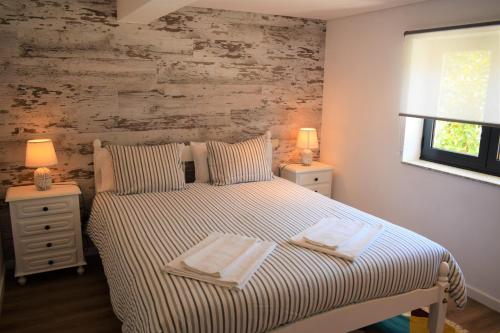 a bedroom with a bed with two towels on it at Casa da Romeira in Ponte de Lima
