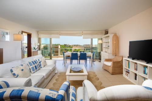 a living room with white couches and a table at Salgados Vila das Lagoas in Albufeira