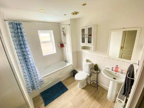 ein Badezimmer mit einer Badewanne, einem WC und einem Waschbecken in der Unterkunft Kings Quarters Boutique Rooms in Hartford