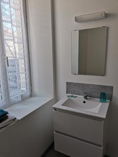 a bathroom with a sink and a mirror and a window at F2 DU GATINAIS in Pithiviers