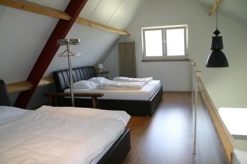 1 dormitorio con 2 camas y ventana en Huisje Wevers, en Bathmen