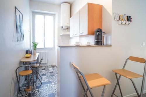 une petite cuisine avec deux chaises et une table dans l'établissement ONLOC - Montpezat Coup de cœur - Hyper Centre - Calme - WIFI, à Pau