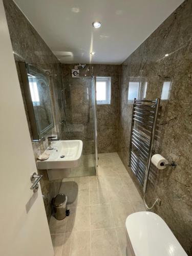 a bathroom with a sink and a shower and a toilet at Anelli Hotel in Southport