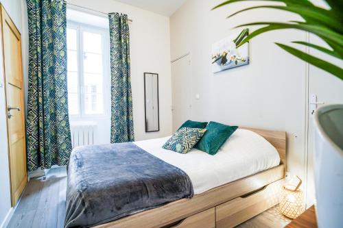 une chambre avec un lit et une grande fenêtre dans l'établissement ONLOC - Montpezat Coup de cœur - Hyper Centre - Calme - WIFI, à Pau