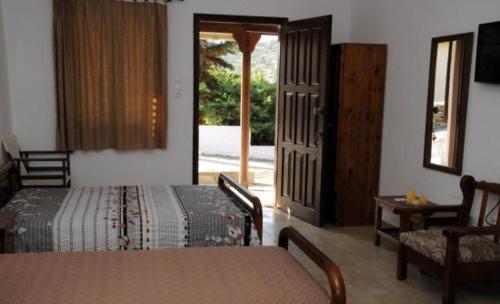 a bedroom with a bed and a door to a patio at Studios Cavo Doro in Otziás