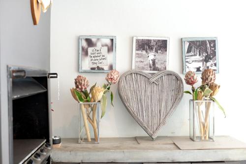 three vases with flowers and a heart on a table at Taunton Manor in Pietermaritzburg