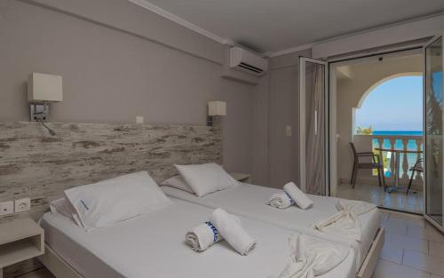 two beds in a bedroom with a view of the ocean at Boletsos Beach in Argasi