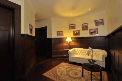 a living room with a white couch and a table at Hotel Casa Higueras in Valparaíso