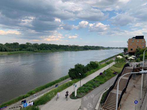 een uitzicht op een rivier met mensen die op een stoep lopen bij Apartments City Center Powiśle in Warschau