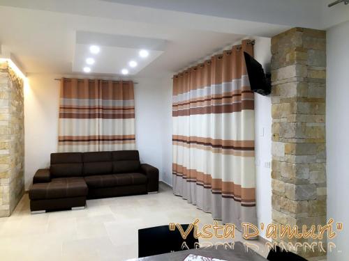 a living room with a couch and curtains at VISTA D'AMURI in Sciacca