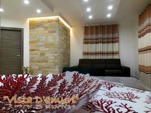 a bedroom with a bed and a living room with a couch at VISTA D'AMURI in Sciacca