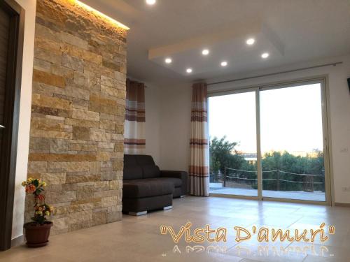 a living room with a stone wall at VISTA D'AMURI in Sciacca