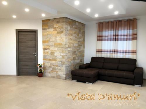 a living room with a couch and a brick wall at VISTA D'AMURI in Sciacca