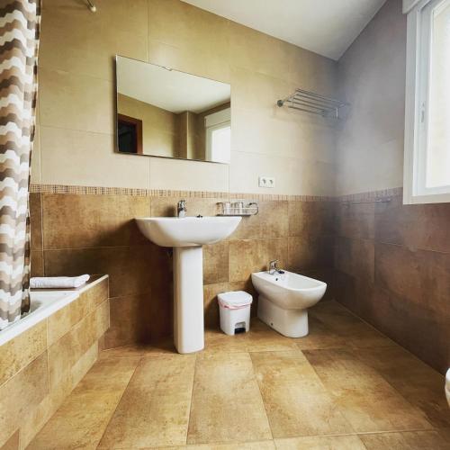 a bathroom with a sink and a toilet and a mirror at Hostal Eden in Sanxenxo