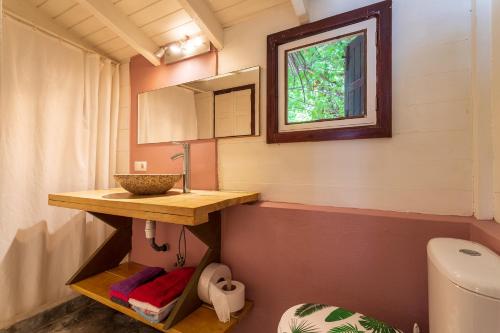 een badkamer met een wastafel, een spiegel en een toilet bij Beach Studio Spock at Lac Bay in Kralendijk