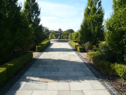 a garden path with a fountain in the middle at New Forest Estate Lodges in Tyrrellspass