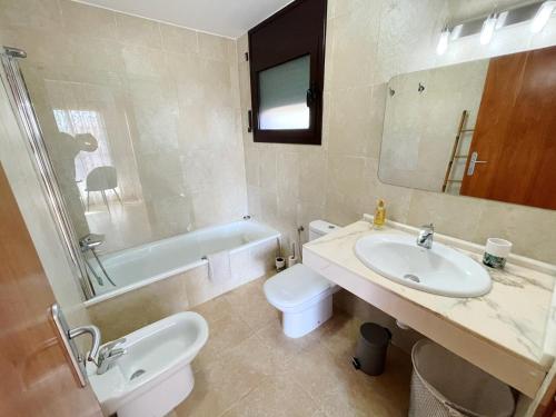 a bathroom with a sink and a toilet and a tub at Casa Dani in L'Ampolla